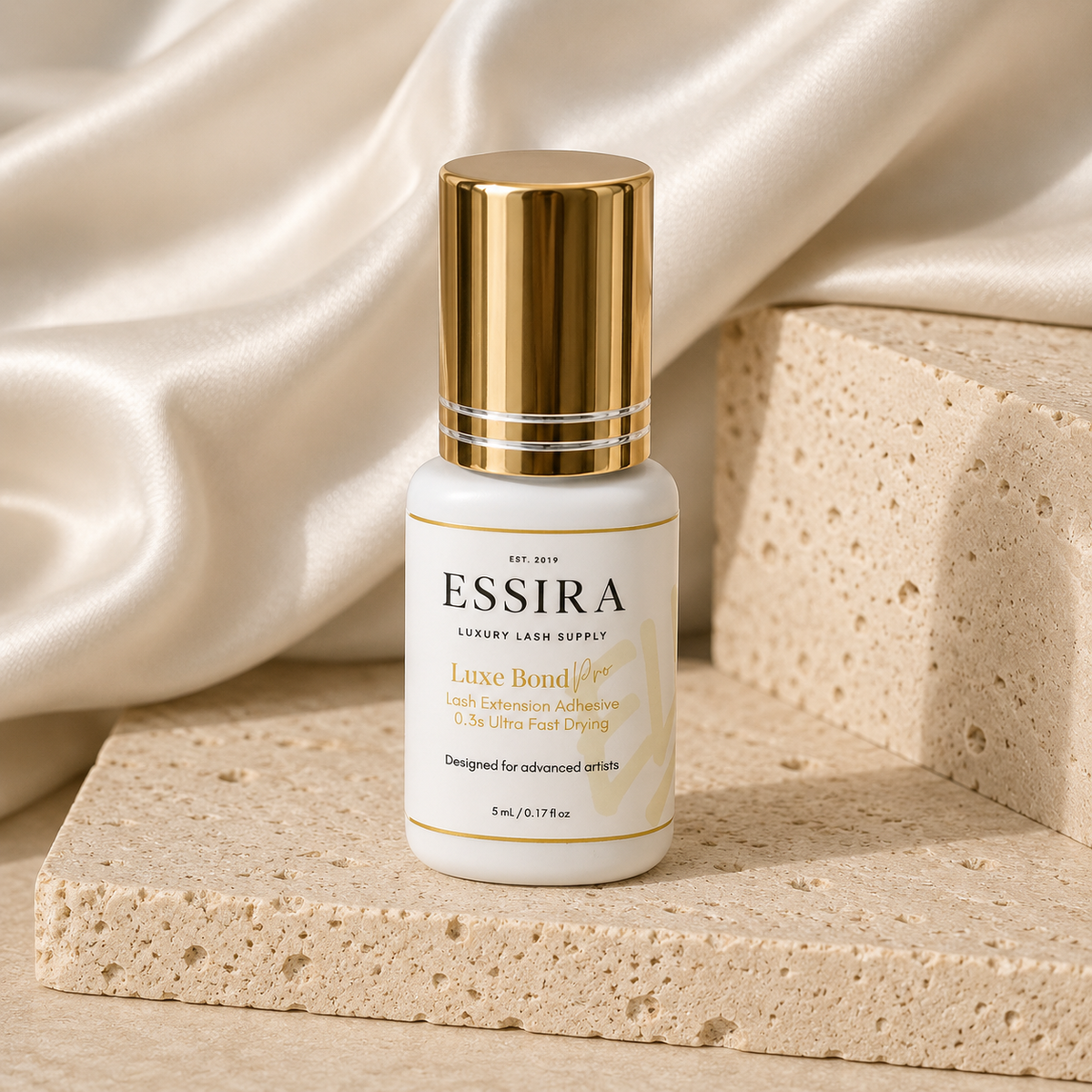 Essira Luxe Bond Pro adhesive on cream satin and travertine background