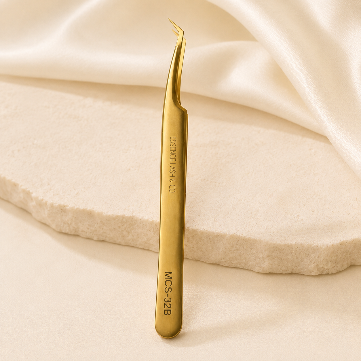 Essira 32B Elite gold volume boot tweezer on cream luxury background
