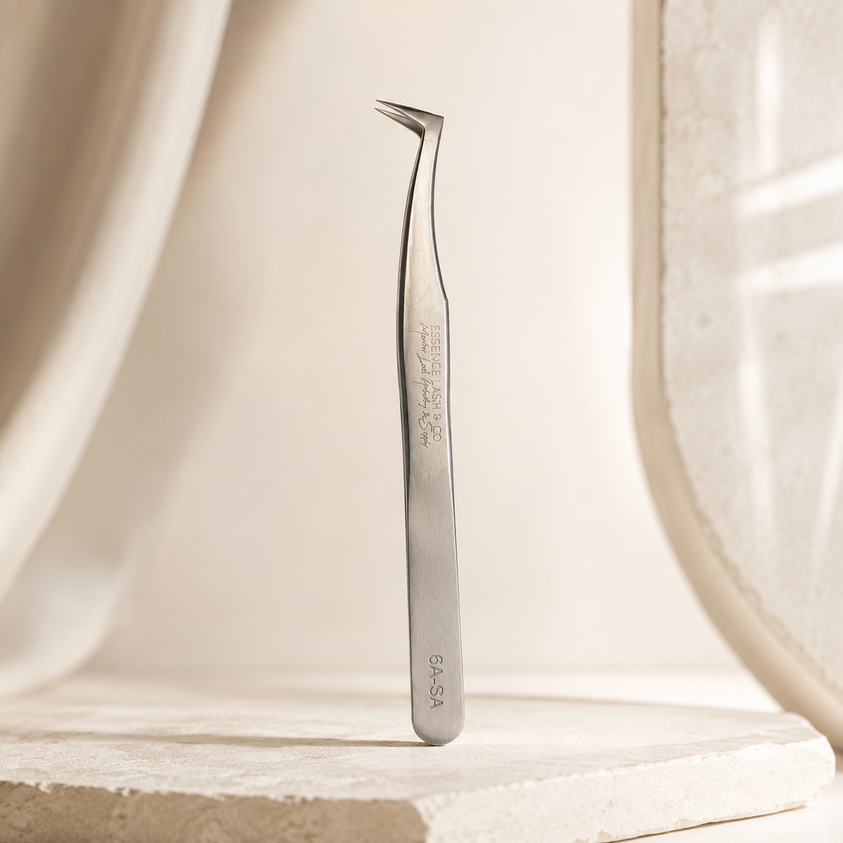 Essira 6A-SA silver ultra volume boot tweezer on a luxury cream background