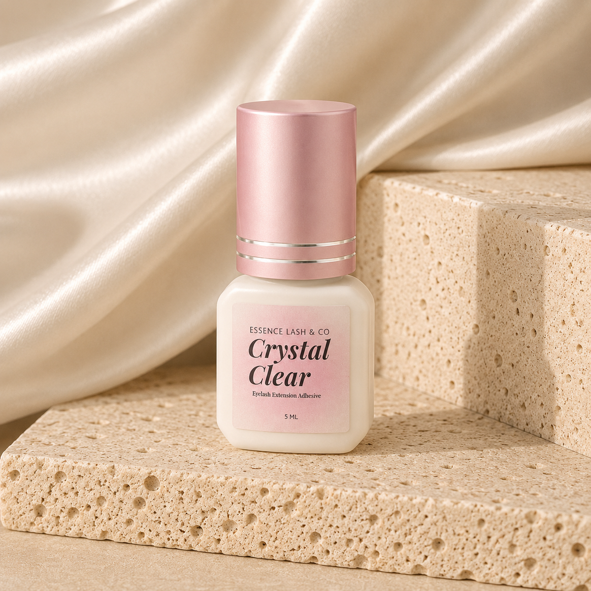 Essira Crystal Clear Adhesive on cream satin and travertine background