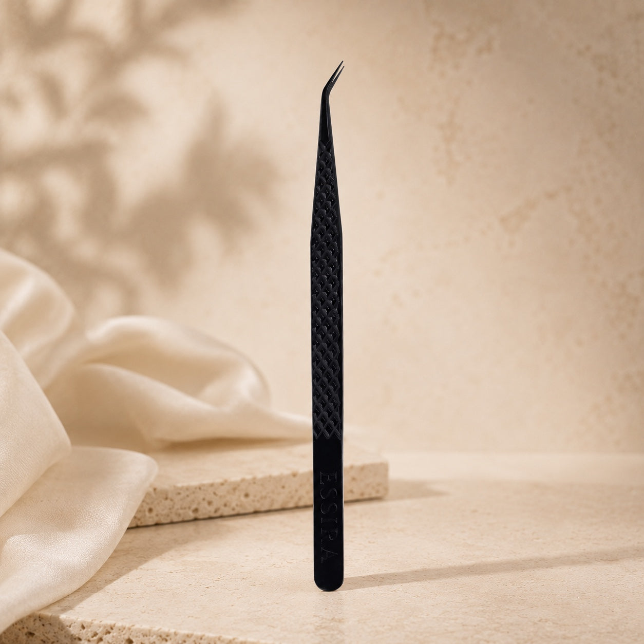 Essira Noir F1 straight isolation tweezer on cream luxury background