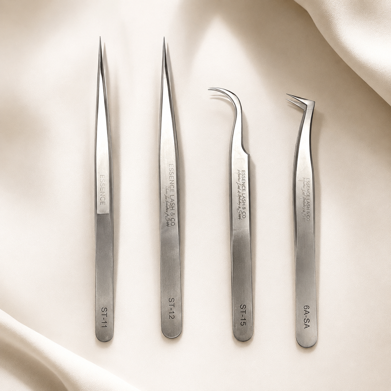 Essira Silver Precision Series four-piece tweezer collection on a luxury cream background