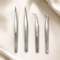 Essira Silver Precision Series four-piece tweezer collection on a luxury cream background