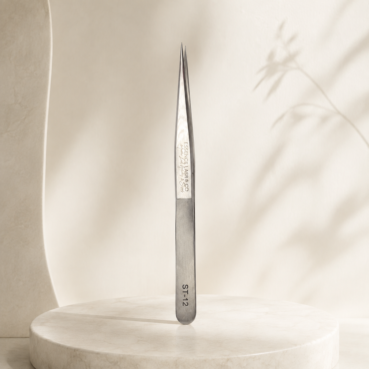 Essira ST-12 silver angled tweezer on a luxury cream background