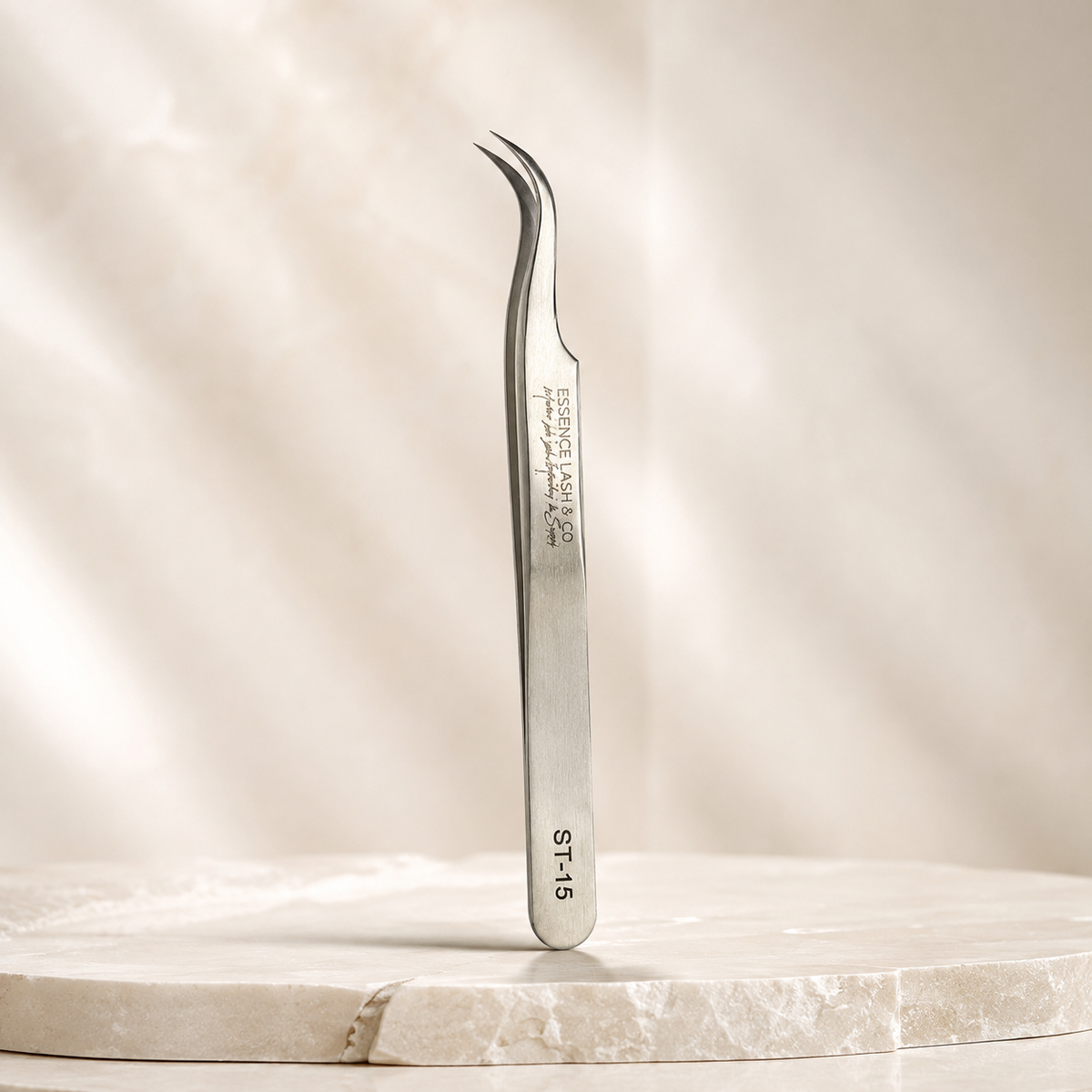 Essira ST-15 silver deep curve tweezer on a luxury cream background